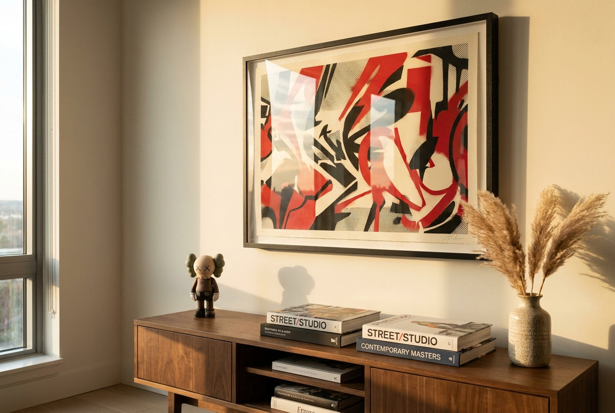 A framed limited-edition street-art screenprint styled above a mid-century console in a modern living room