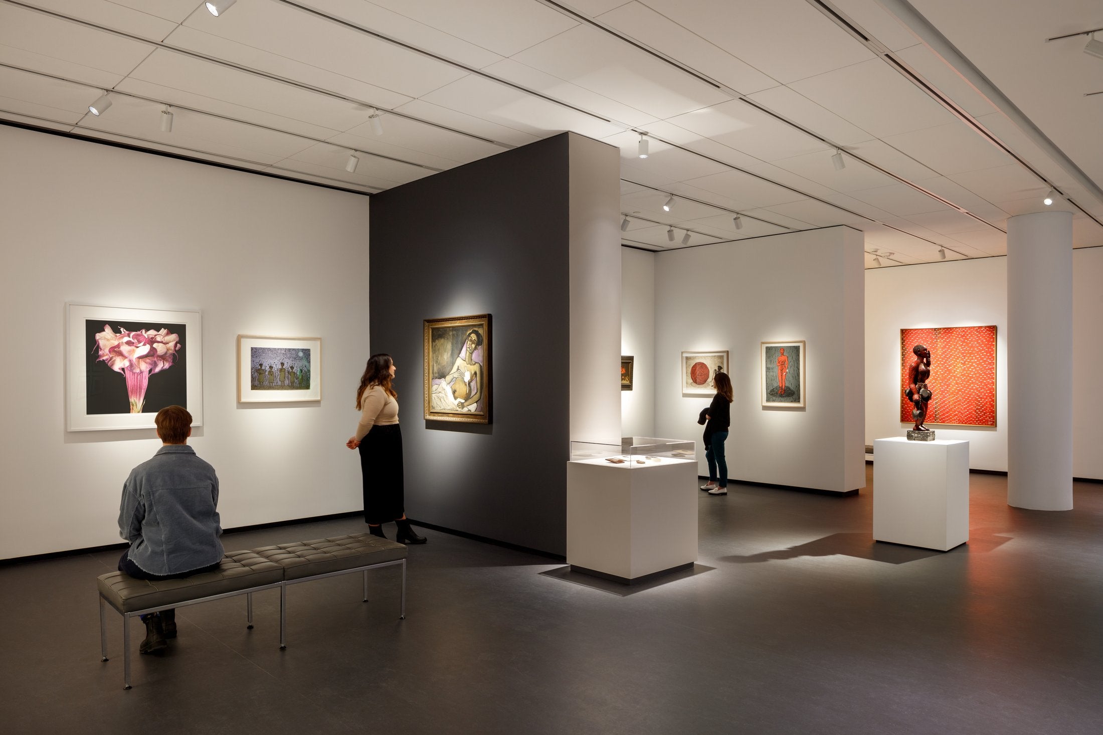 Inside the gallery — framed works and sculpture under museum lighting